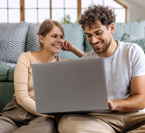 Casal conversando no sofá com notebook